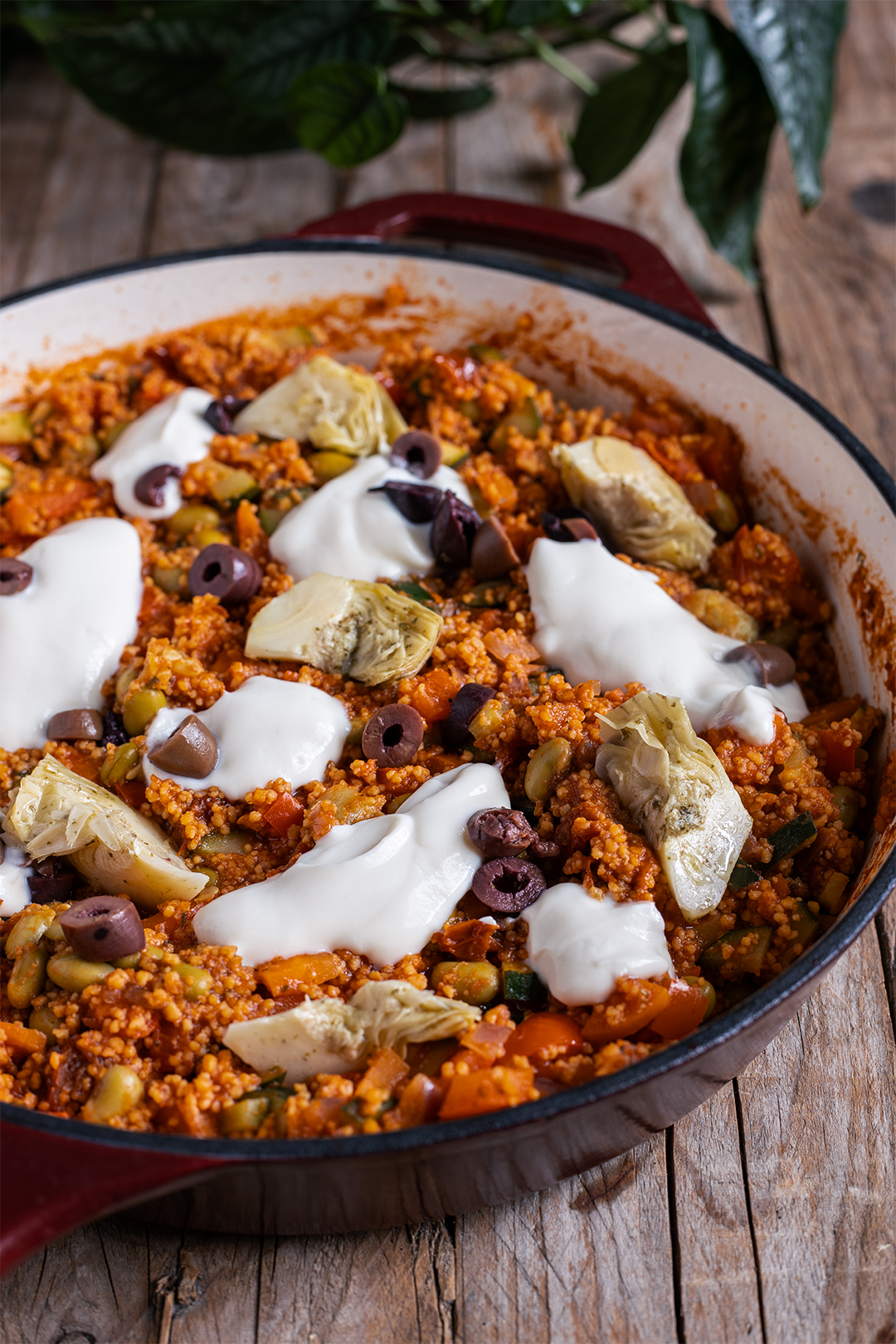 Vegane Couscous-Pfanne mit Gemüse, Edamame, Oliven und Artischocken in einer weiten Pfanne