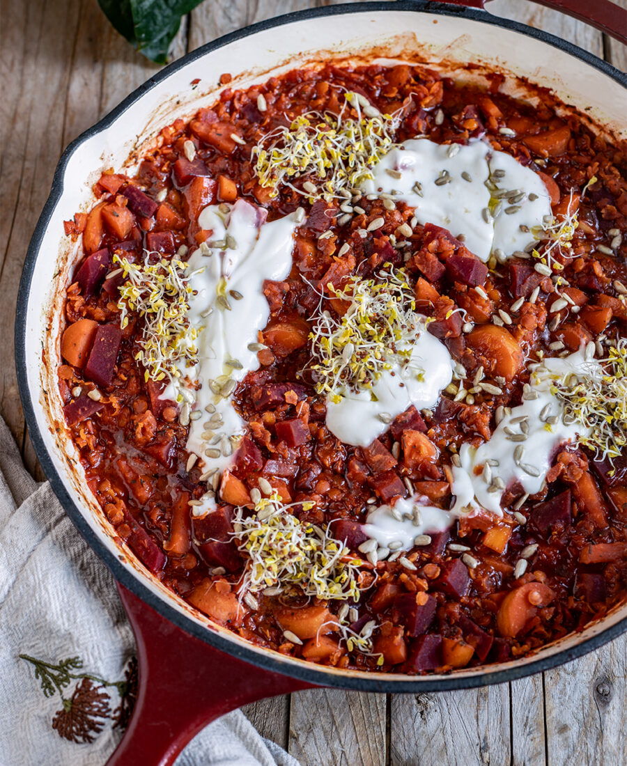 Rote Bete Linsen Pfanne, vegan, in der Pfanne serviert mit Pflanzenjoghurt, Brokkolisprossen und gerösteten Sonnenblumenkernen